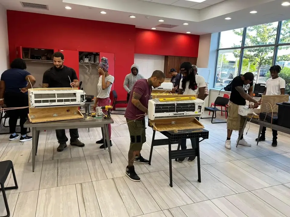 A Tauris Tech class at benches, each student wiring an open mini-split indoor unit