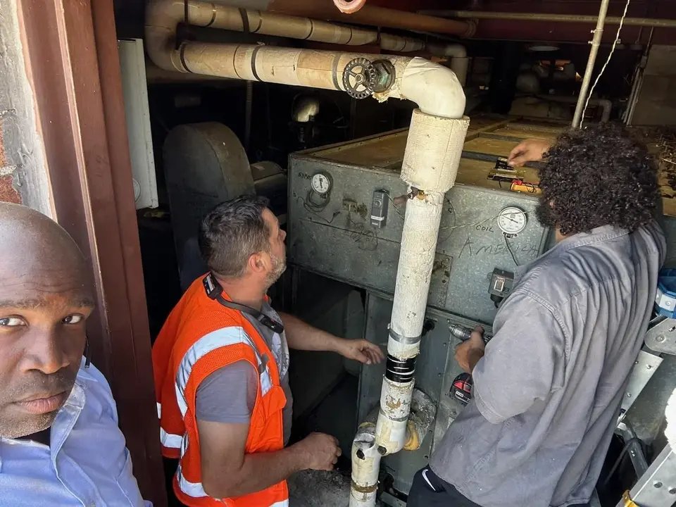 Tauris Tech students working on pipework in a New York City mechanical room